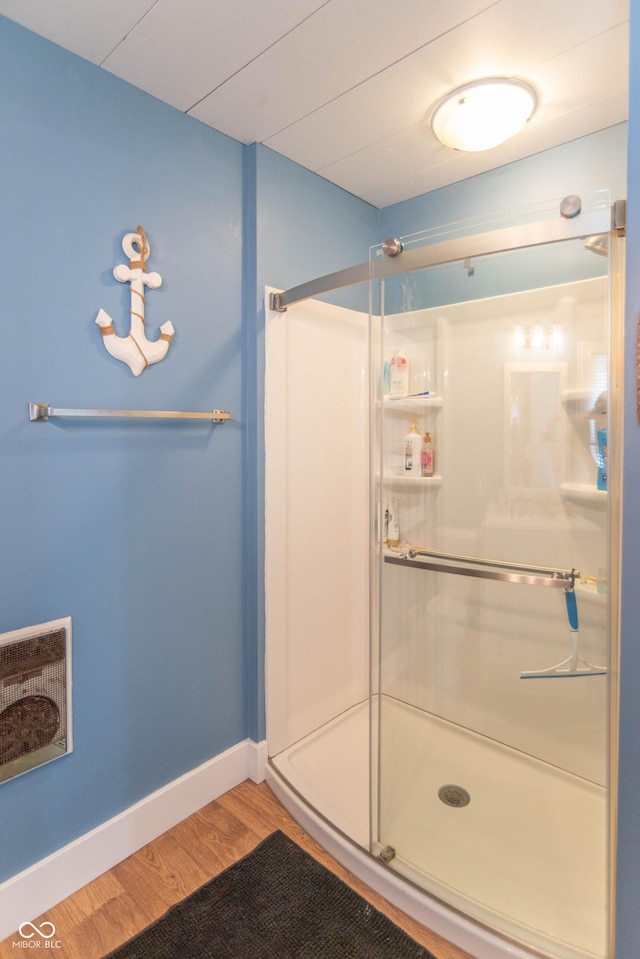 full bath featuring visible vents, wood finished floors, and a stall shower