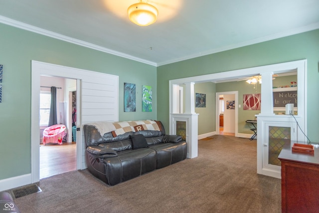 living area featuring carpet floors, ornate columns, and ornamental molding