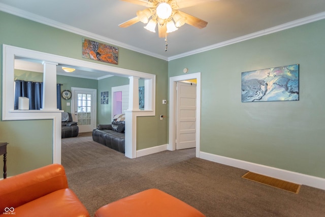 living area featuring carpet floors, a ceiling fan, baseboards, decorative columns, and ornamental molding
