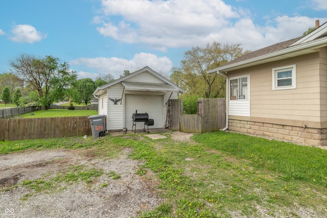 view of outbuilding with fence and dirt driveway