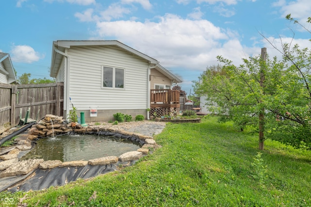 back of property featuring a lawn, fence, and a wooden deck