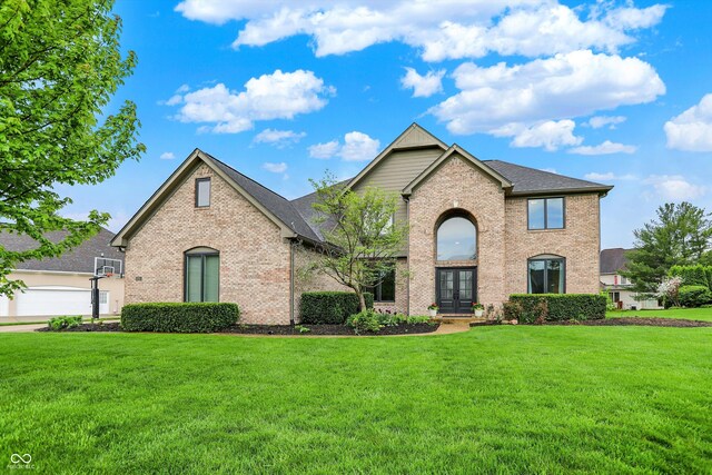 traditional-style home with brick siding, french doors, and a front yard