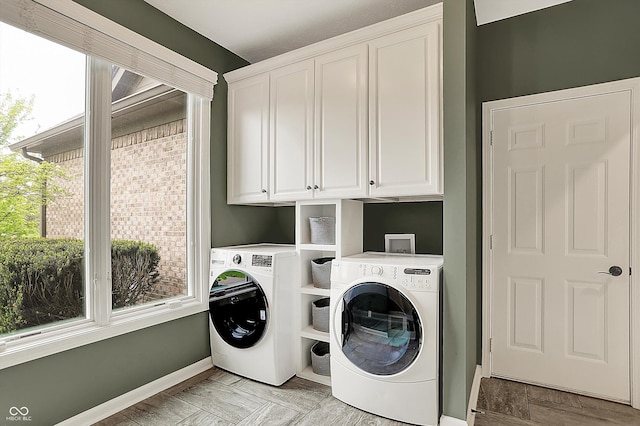washroom with cabinet space, separate washer and dryer, and baseboards