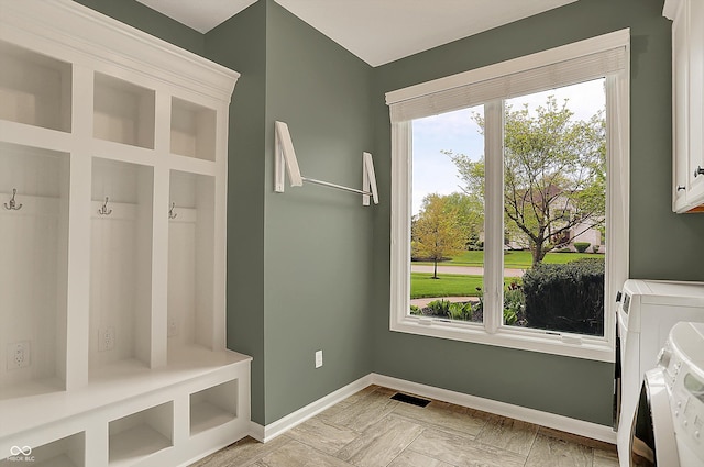 mudroom featuring separate washer and dryer, baseboards, and visible vents