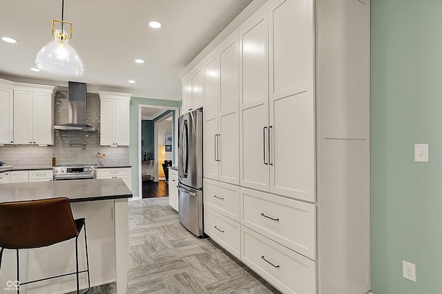 kitchen with white cabinets, wall chimney exhaust hood, stainless steel appliances, decorative light fixtures, and recessed lighting