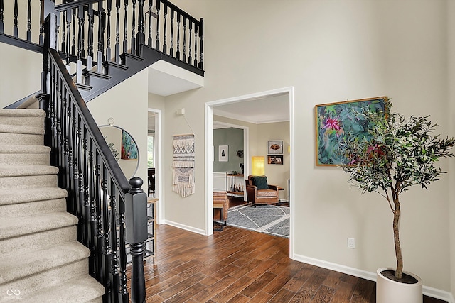 foyer with baseboards, stairs, a high ceiling, and dark wood-style floors