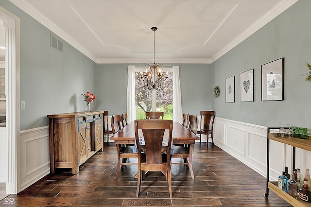 dining area featuring an inviting chandelier, crown molding, a decorative wall, and dark wood-type flooring