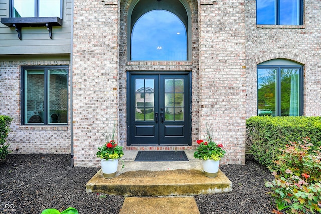 property entrance featuring brick siding and french doors