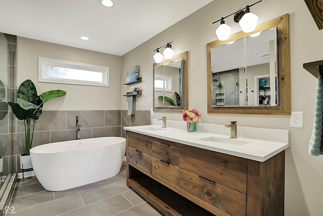bathroom featuring a sink, tile walls, tile patterned flooring, and a soaking tub