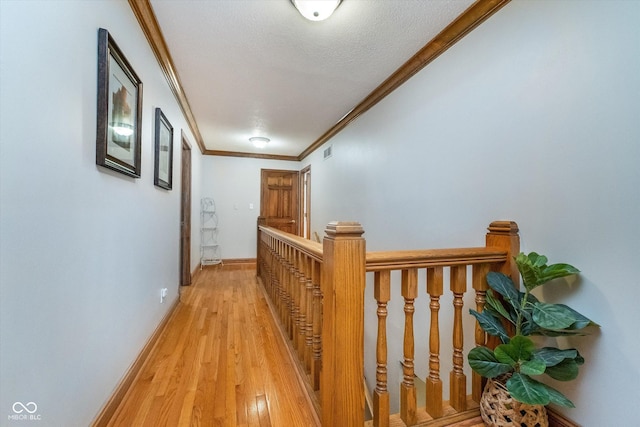 4401 W Hunters Ridge Ln W, Greenwood, IN 46143 - hallway with visible vents, crown molding, light wood-type flooring, baseboards, and an upstairs landing
