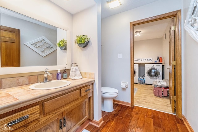 4401 W Hunters Ridge Ln W, Greenwood, IN 46143 - bathroom featuring wood finished floors, vanity, baseboards, toilet, and washer and dryer