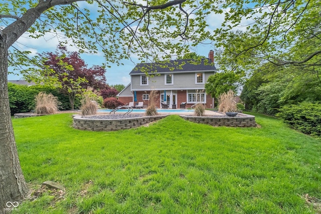 4401 W Hunters Ridge Ln W, Greenwood, IN 46143 - back of house with brick siding, an outdoor pool, and a lawn