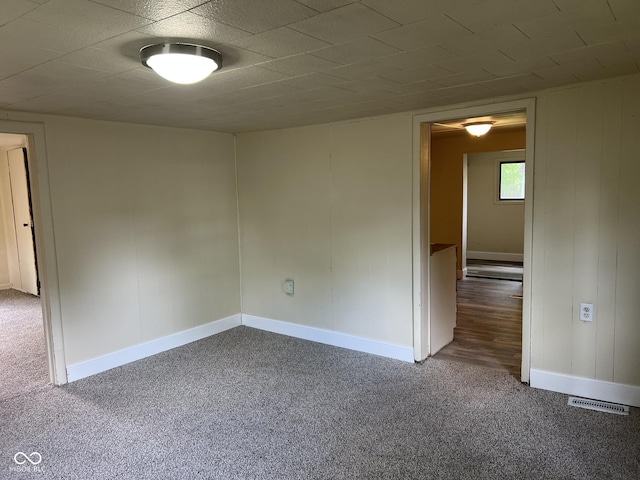 spare room with baseboards, carpet, and visible vents