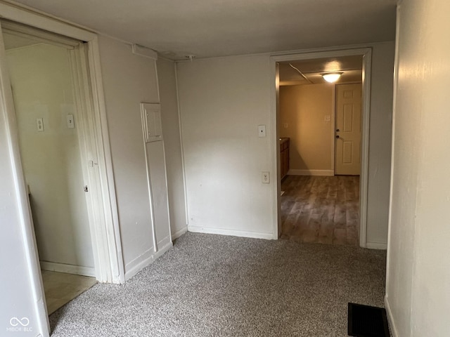 unfurnished room featuring baseboards, visible vents, and carpet