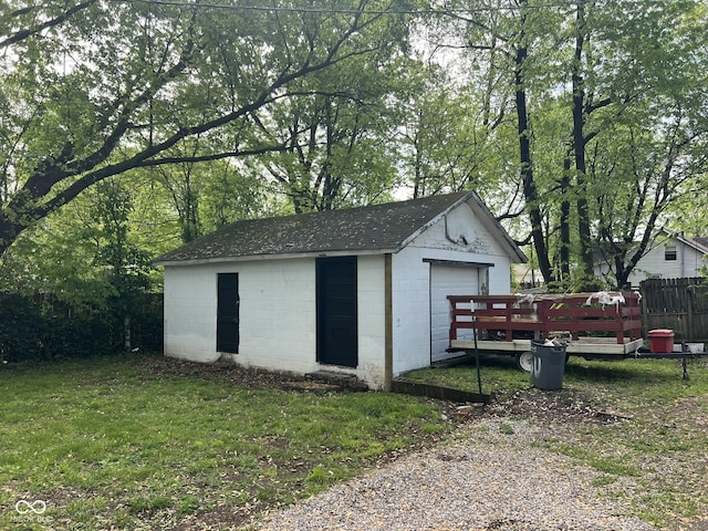 detached garage featuring fence and driveway