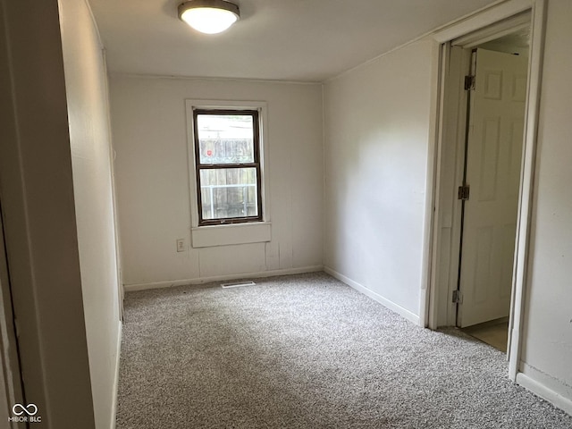carpeted spare room featuring baseboards and visible vents