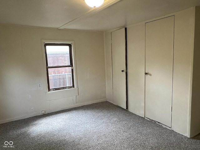 unfurnished bedroom with carpet floors and baseboards