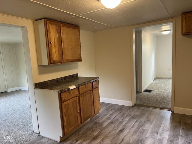 kitchen with brown cabinets, dark countertops, and baseboards