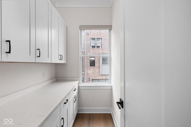interior space with white cabinets, baseboards, and dark wood finished floors