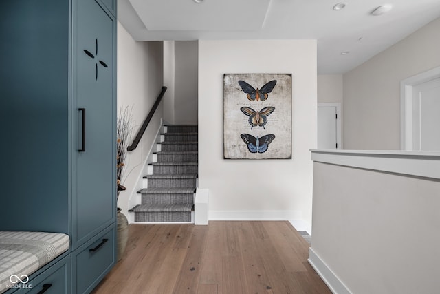 staircase with baseboards, recessed lighting, and wood finished floors