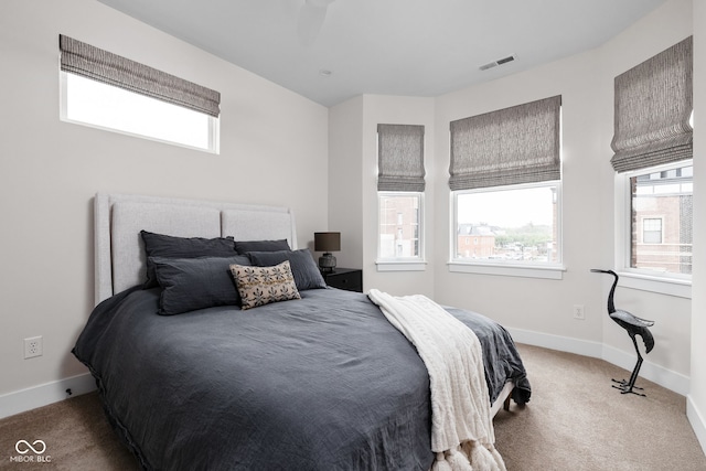 bedroom with carpet flooring, baseboards, visible vents, and multiple windows