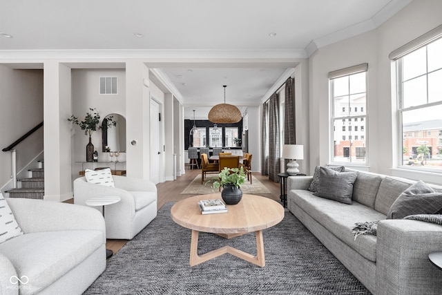 living area with recessed lighting, wood finished floors, visible vents, ornamental molding, and stairway