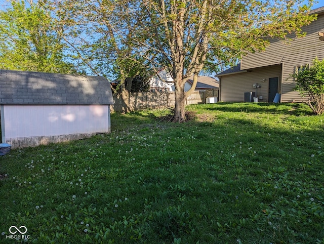 view of yard featuring a shed, an outbuilding, and central AC