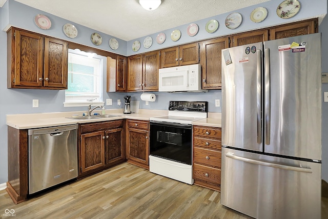 11620 E 75th St, Indianapolis, IN 46236 - kitchen featuring stainless steel appliances, a sink, light wood finished floors, light countertops, and a textured ceiling