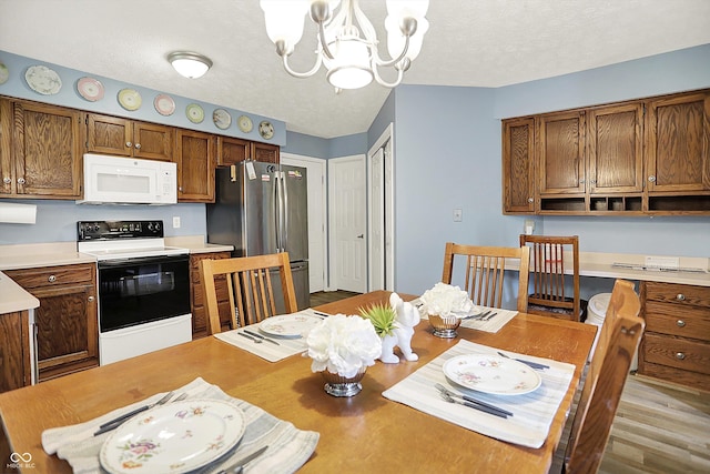 11620 E 75th St, Indianapolis, IN 46236 - dining room featuring a chandelier, a textured ceiling, and wood finished floors