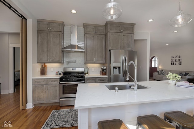 825 Iowa St, Indianapolis, IN 46203 - kitchen featuring a sink, stainless steel appliances, dark wood-style flooring, wall chimney range hood, and tasteful backsplash