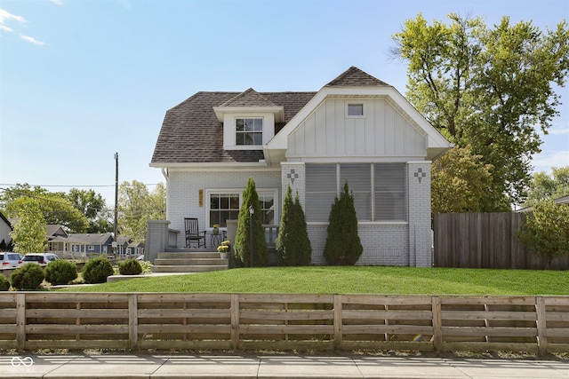 825 Iowa St, Indianapolis, IN 46203 - view of front of home featuring brick siding, a front yard, a fenced front yard, board and batten siding, and a shingled roof