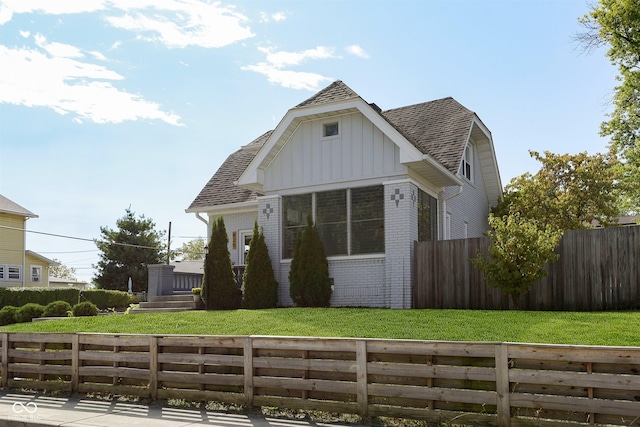 825 Iowa St, Indianapolis, IN 46203 - bungalow-style home featuring roof with shingles, fence private yard, brick siding, and board and batten siding