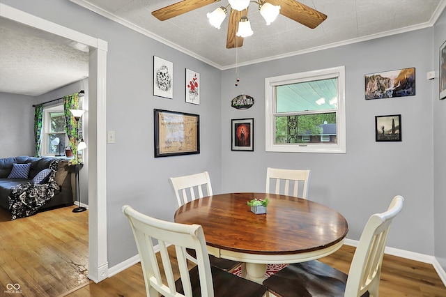 dining room featuring plenty of natural light, baseboards, ceiling fan, and wood finished floors