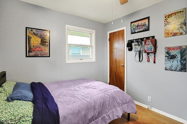 bedroom featuring baseboards, ceiling fan, and wood finished floors