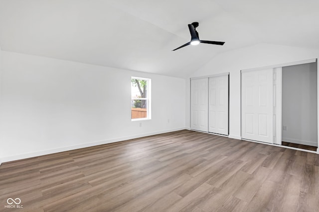 555 S Auburn St, Indianapolis, IN 46241 - unfurnished bedroom with wood finished floors, two closets, baseboards, a ceiling fan, and vaulted ceiling