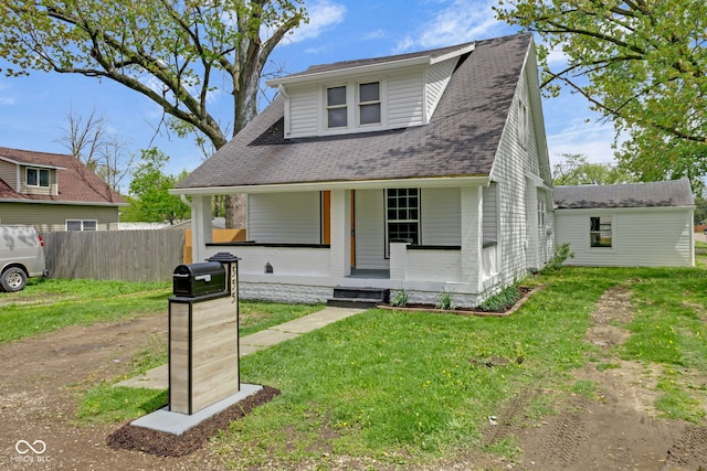 555 S Auburn St, Indianapolis, IN 46241 - view of front facade featuring fence, a front yard, roof with shingles, brick siding, and a porch