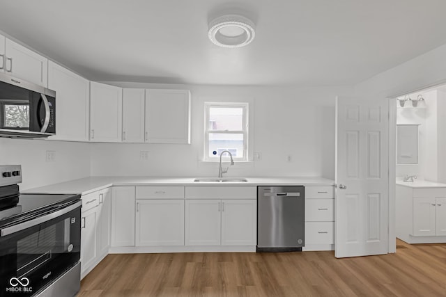 555 S Auburn St, Indianapolis, IN 46241 - kitchen featuring white cabinets, stainless steel appliances, a sink, and light wood finished floors