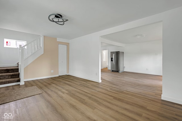 555 S Auburn St, Indianapolis, IN 46241 - unfurnished living room with stairway, baseboards, and wood finished floors