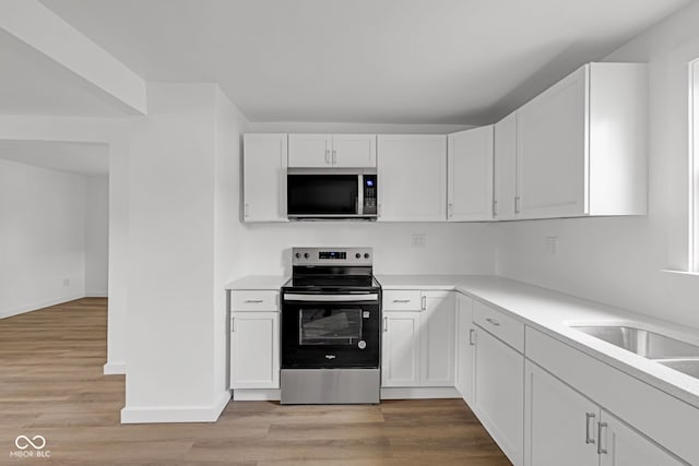 555 S Auburn St, Indianapolis, IN 46241 - kitchen featuring light countertops, stainless steel appliances, light wood-type flooring, and white cabinetry