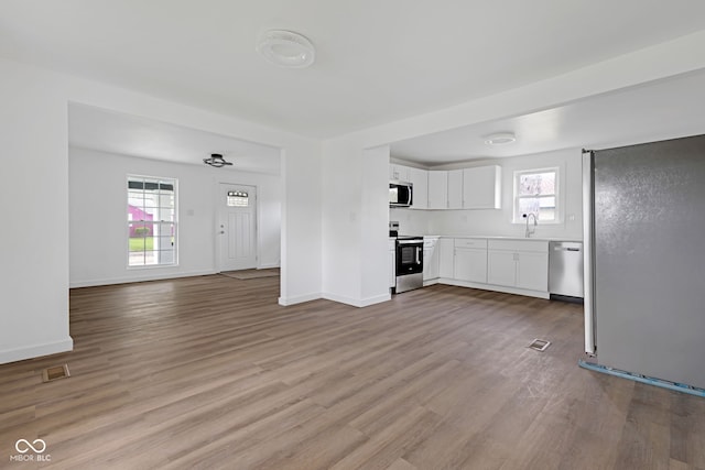 555 S Auburn St, Indianapolis, IN 46241 - unfurnished living room featuring a sink, wood finished floors, and a wealth of natural light