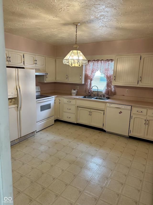 318 Elva St, Anderson, IN 46013 - kitchen featuring a textured ceiling, pendant lighting, a sink, under cabinet range hood, and white appliances