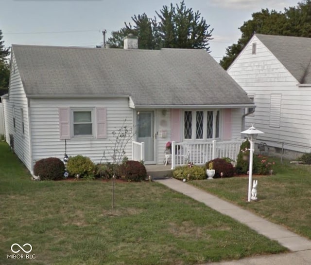 318 Elva St, Anderson, IN 46013 - new england style home with a porch, a shingled roof, and a front lawn