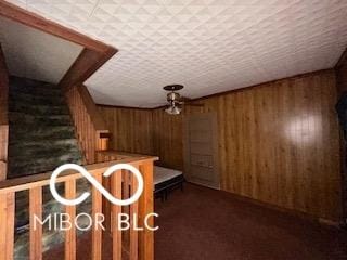 interior space with carpet flooring and wooden walls