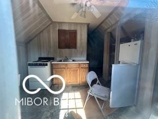 interior space with a sink, lofted ceiling, light countertops, a ceiling fan, and range