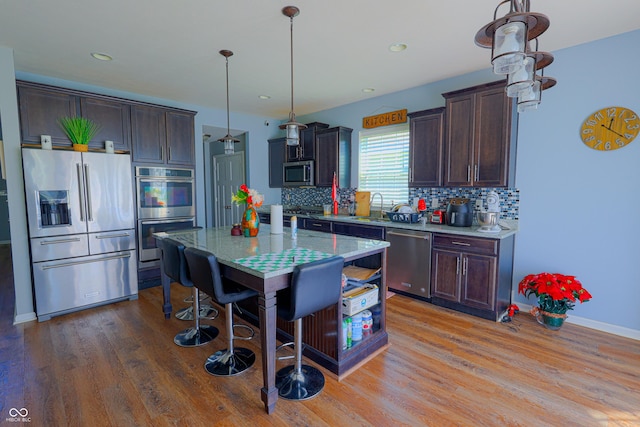 9993 Pepper Tree Ln, Noblesville, IN 46060 - kitchen with backsplash, stainless steel appliances, dark brown cabinetry, and light wood-style flooring