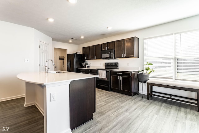 6559 Ambrosia Ln, Pendleton, IN 46064 - kitchen with baseboards, light wood-type flooring, light countertops, a sink, and black appliances