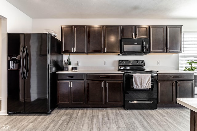 6559 Ambrosia Ln, Pendleton, IN 46064 - kitchen with light countertops, dark brown cabinets, black appliances, and light wood-style floors