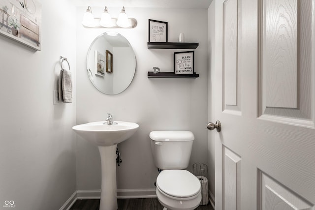 6559 Ambrosia Ln, Pendleton, IN 46064 - half bathroom featuring toilet, baseboards, a sink, and wood finished floors