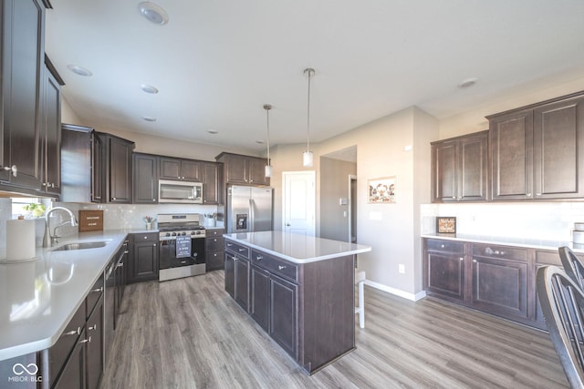 657 Kilmore Dr, Pendleton, IN 46064 - kitchen featuring dark brown cabinetry, light wood-type flooring, stainless steel appliances, and a sink