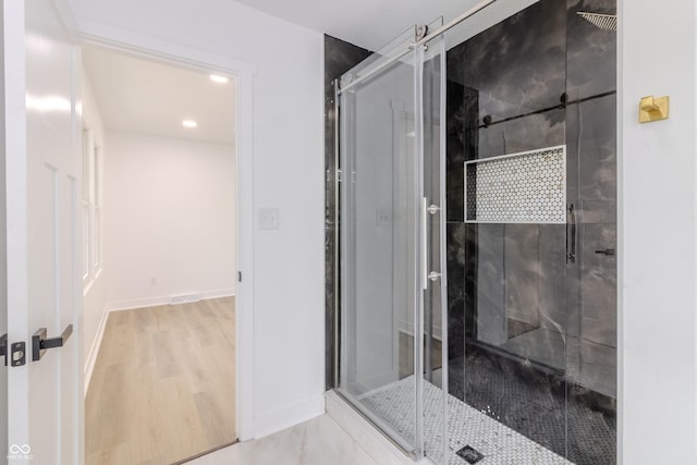 bathroom featuring baseboards, a stall shower, recessed lighting, and wood finished floors